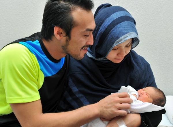 Khairul Fahmi (kiri) dan Leuniey tersenyum gembira memerhatikan gelagat bayi perempuan mereka.