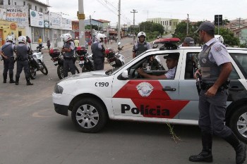 Policemen are deployed at Vida Nova bus station, in Campinas, some 96 km from Sao Paulo, Brazil on January 13, 2013, after people torched buses and attacked cars to protest for the killing overnight of twelve people in a surge of violence that began with the murder of an off-duty policeman. AFP PHOTO / Denny CESARE