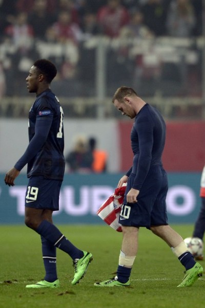Manchester United's English forward Wayne Rooney (R) and English forward Danny Welbeck walk off the pitch after losing the round of 16 Champions League football match Olympiakos vs Manchester United at Karaiskaki Stadium in Athens on February 25, 2014. AFP PHOTO / ARIS MESSINIS