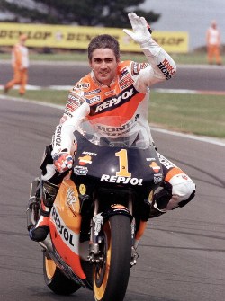Reigning five-time World Champion Mick Doohan of Australia waves to fans during a lap of honour before the start of the 1999 Australian 500cc Motorcycle Grand Prix on Phillip Island 03 October 1999. Doohan was unable to race due to injures sustained on the first day of the Spanish Grand Prix in Jerez in May. AFP PHOTO/Nigel PATERSON